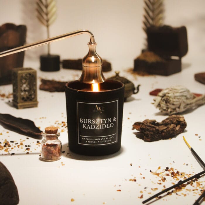 Świeca Bursztyn & Kadzidło AV Light Candle 130 ml zgaszona eleganckim gasidłem, w stylizowanej aranżacji orientalnej
