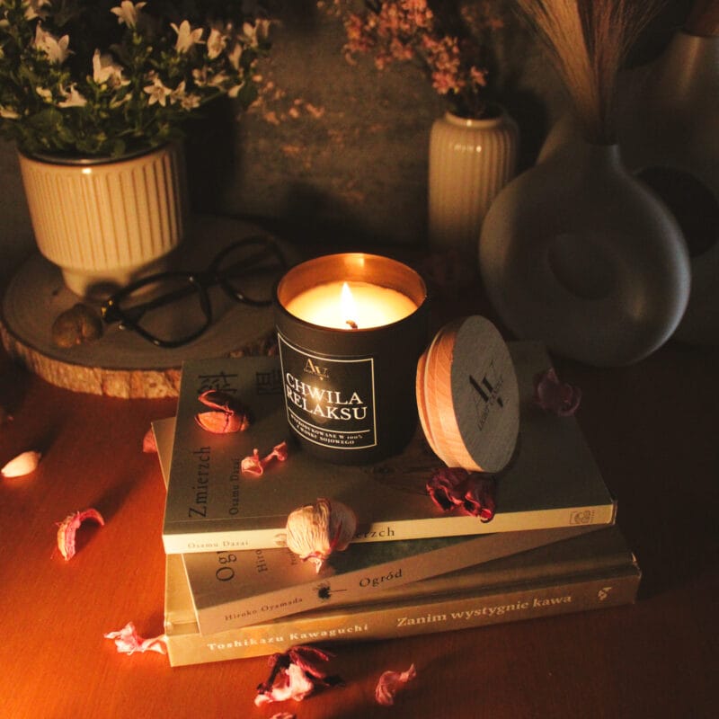 Świeca AV Light Candle w zapachu Chwila Relaksu, w matowym szkle, w otoczeniu naturalnych dodatków, symbolizująca spokojny wieczór.