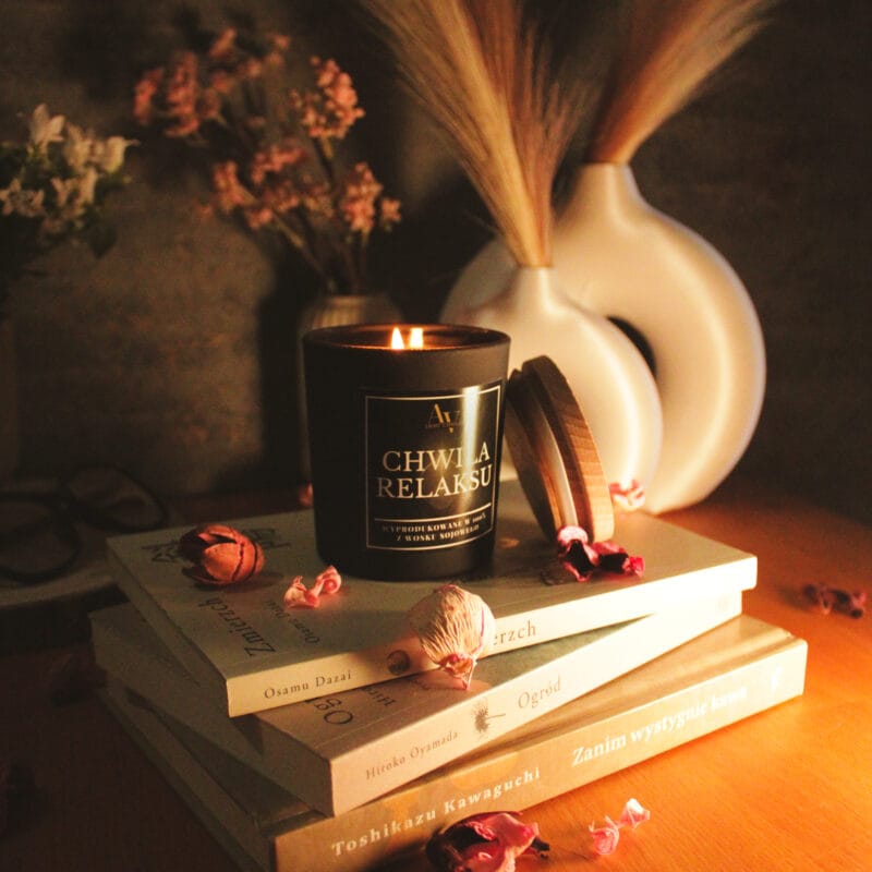 Świeca AV Light Candle w zapachu Chwila Relaksu, w matowym szkle, w otoczeniu naturalnych dodatków, symbolizująca spokojny wieczór.