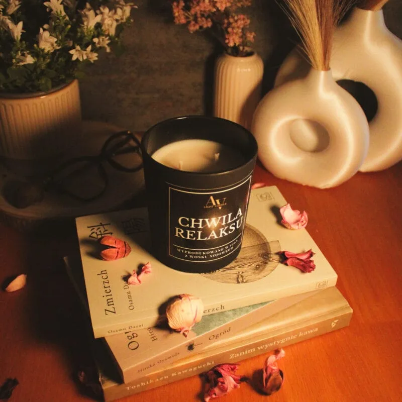 Świeca AV Light Candle w zapachu Chwila Relaksu, w matowym szkle, w otoczeniu naturalnych dodatków, symbolizująca spokojny wieczór.