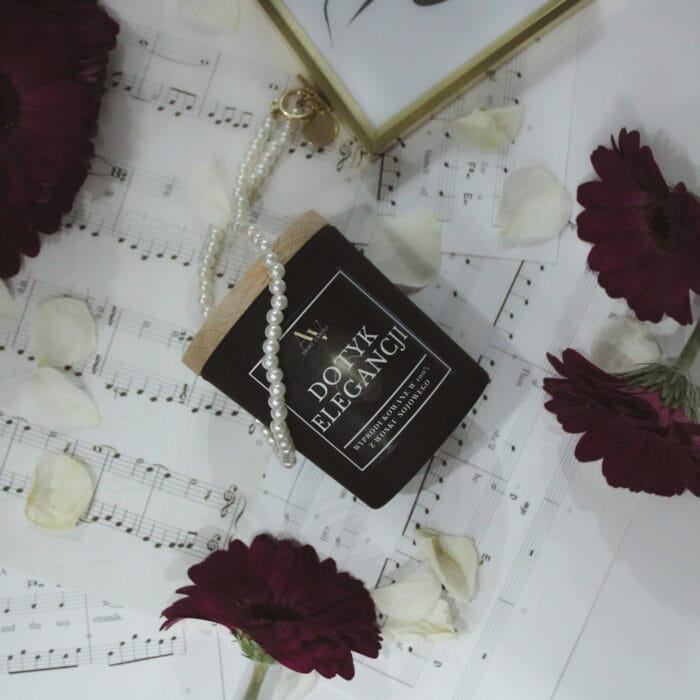 świeca sojowa Dotyk Elegancji AV Light Candle kolekcja Ember 130 ml na tle nut muzycznych z perełkami i płatkami róż