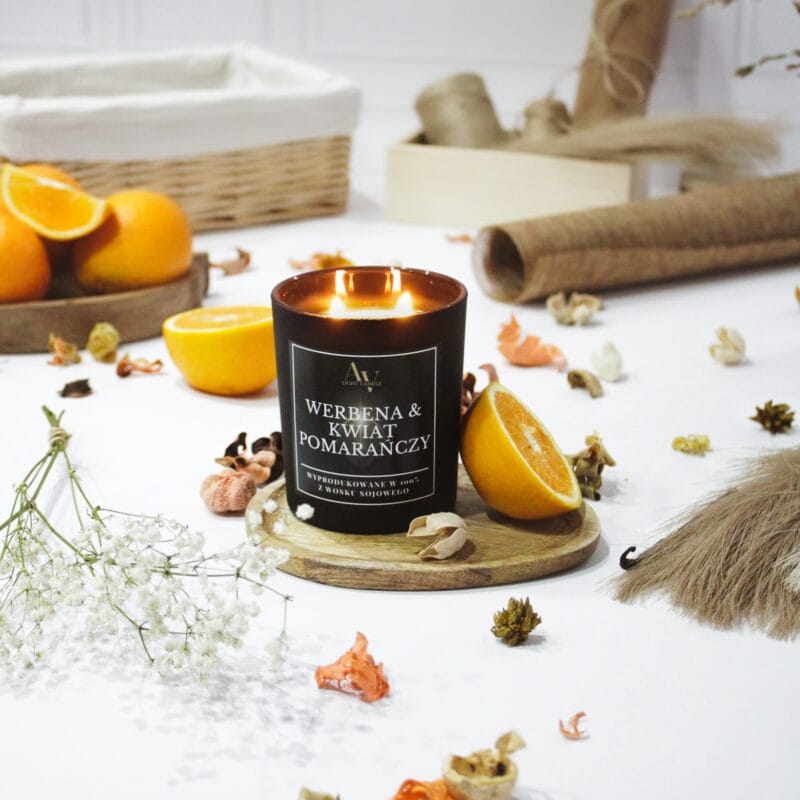 Świeca sojowa Werbena i Kwiat Pomarańczy AV Light Candle – kolekcja Lumor 280 ml z dwoma knotami, zapalona wśród suszonych kwiatów i pomarańczy.