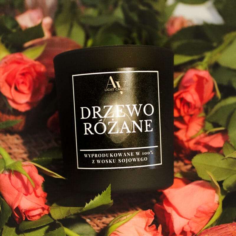 Zbliżenie świecy Drzewo Różane AV Light Candle wśród różowych róż