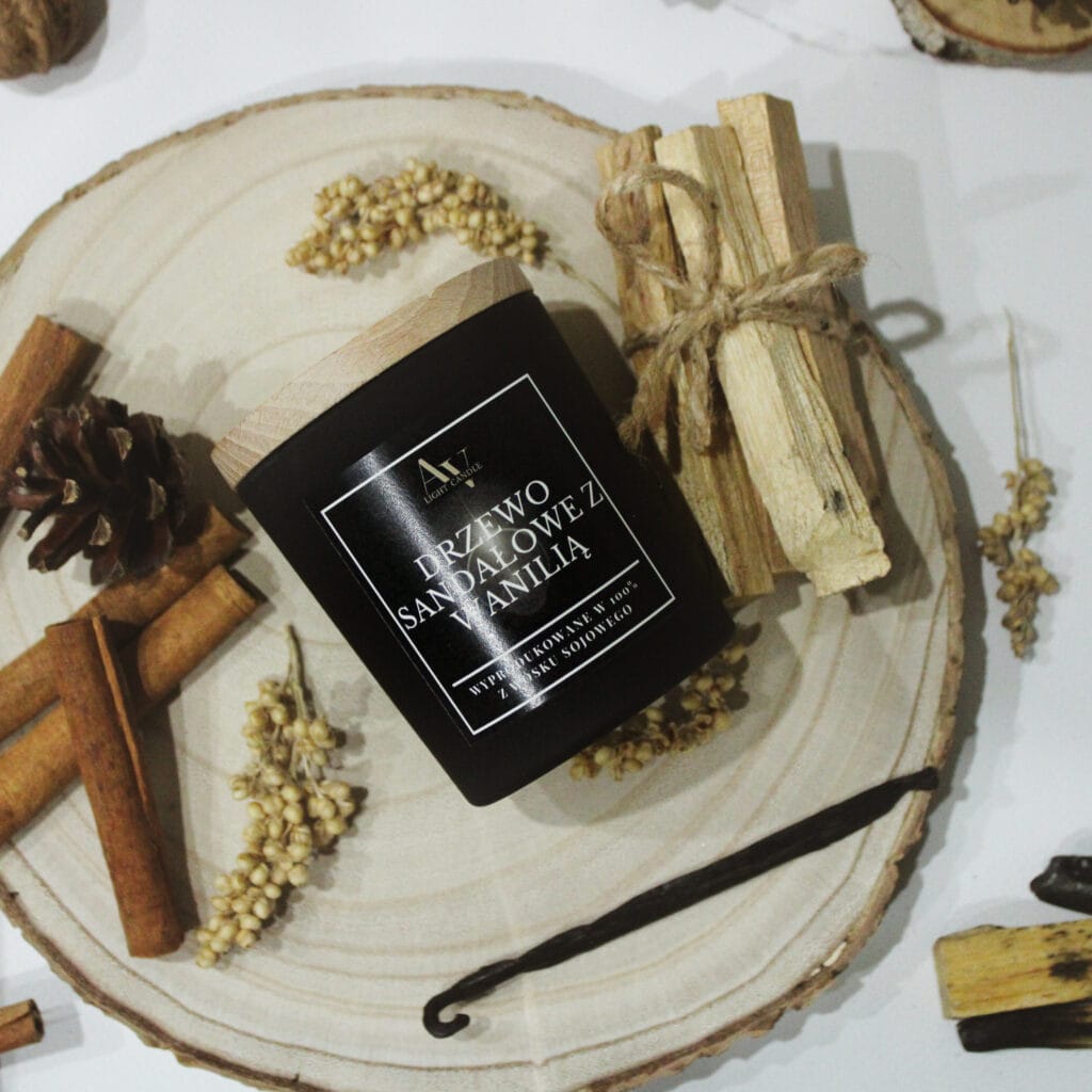 Świeca sojowa Drzewo Sandałowe z Wanilią AV Light Candle na naturalnej podstawie z drewna, otoczona laskami cynamonu, wanilią i palo santo