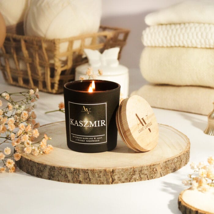 Płonąca świeca Kaszmir AV Light Candle z pokrywką w tle z włóczką i kocami