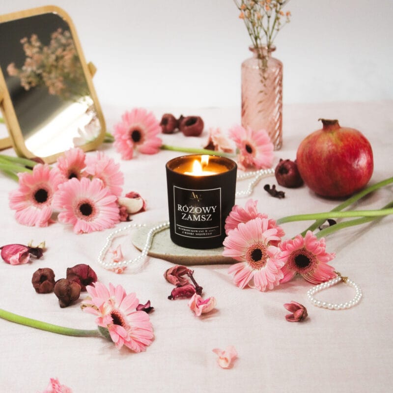 Zapalona świeca Różowy Zamsz AV Light Candle w aranżacji z kwiatami i granatem
