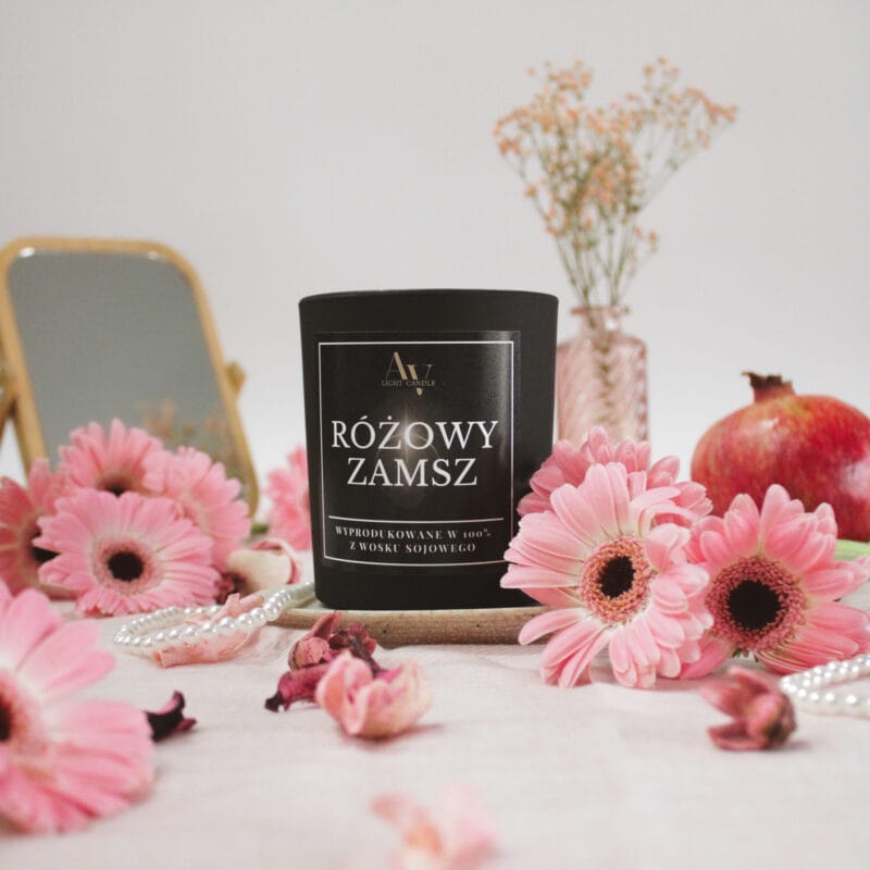 Świeca Różowy Zamsz Lumor AV Light Candle w scenerii z lustrem, kwiatami i owocem granatu