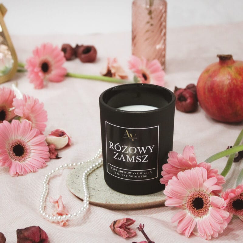 Świeca Różowy Zamsz AV Light Candle 200 ml w wersji z nieodpalonym knotem, na tle kwiatów i owocu granatu.