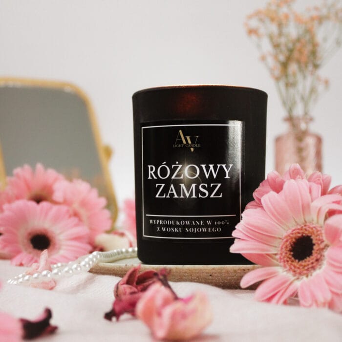 Zbliżenie na świecę Różowy Zamsz AV Light Candle 200 ml w otoczeniu pastelowych kwiatów i pereł.