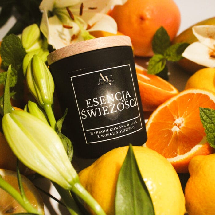Świeca sojowa Esencja Świeżości AV Light Candle 130 ml z drewnianym wieczkiem, otoczona świeżymi cytrusami i kwiatami.