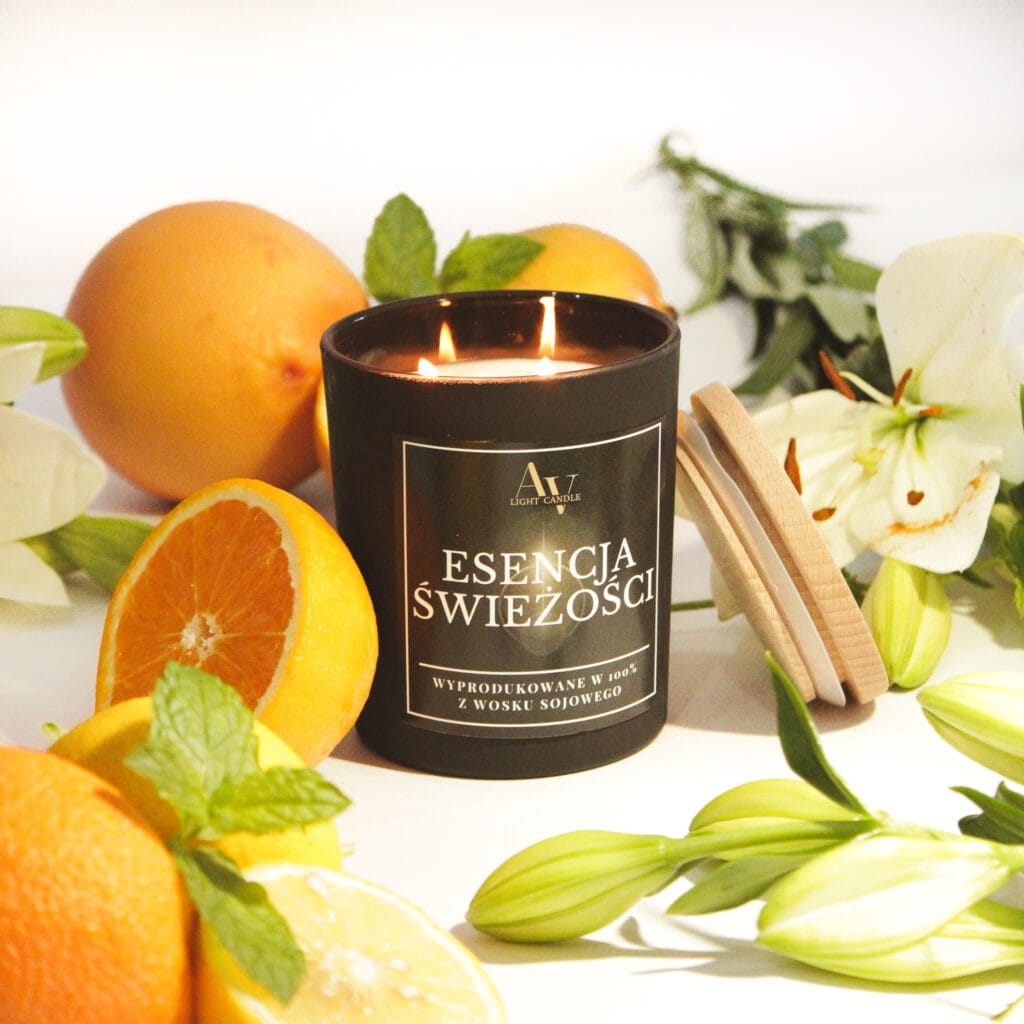 świeca sojowa Esencja Świeżości Lumor 280 ml z dwoma knotami w czarnym szkle, otoczona owocami i kwiatami