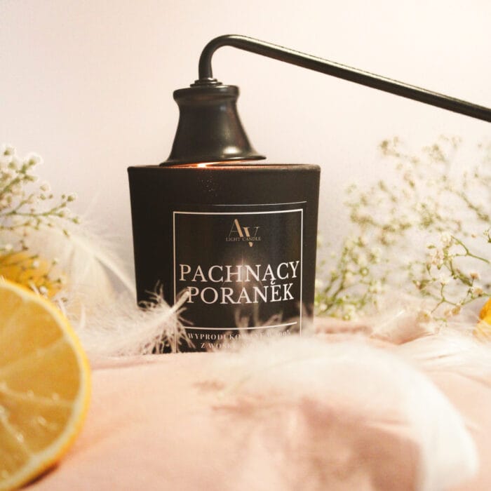 płonąca świeca pachnący poranek ember 130 ml w czarnym słoiku z cytrynami i piórami.