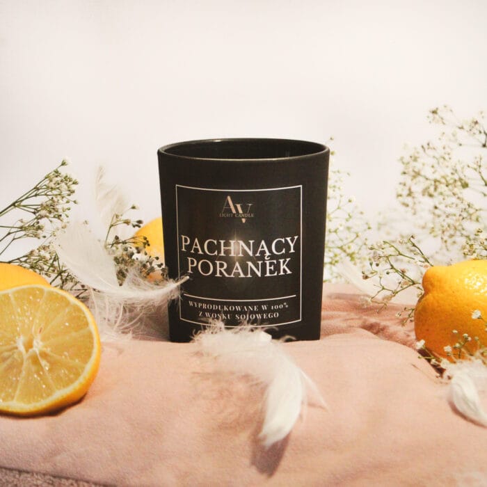 Świeca Pachnący Poranek Lumor 280 ml z cytrynami i gipsówką na jasnoróżowym tle.
