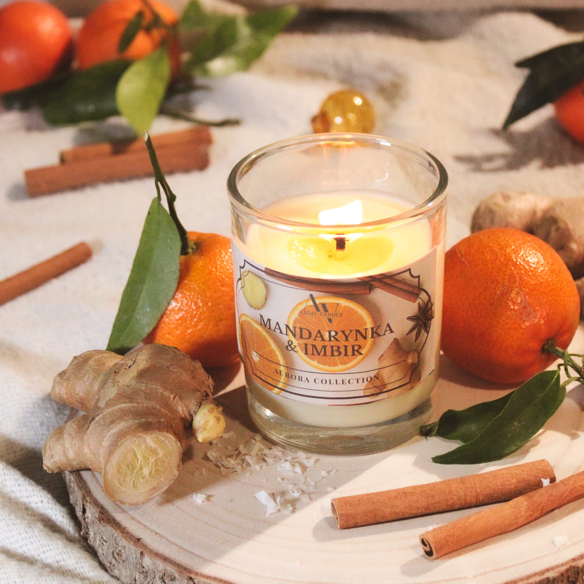 Świeca Mandarynka & Imbir 200 ml – widok z góry, ciepła aranżacja z owocami, imbirem i laskami cynamonu