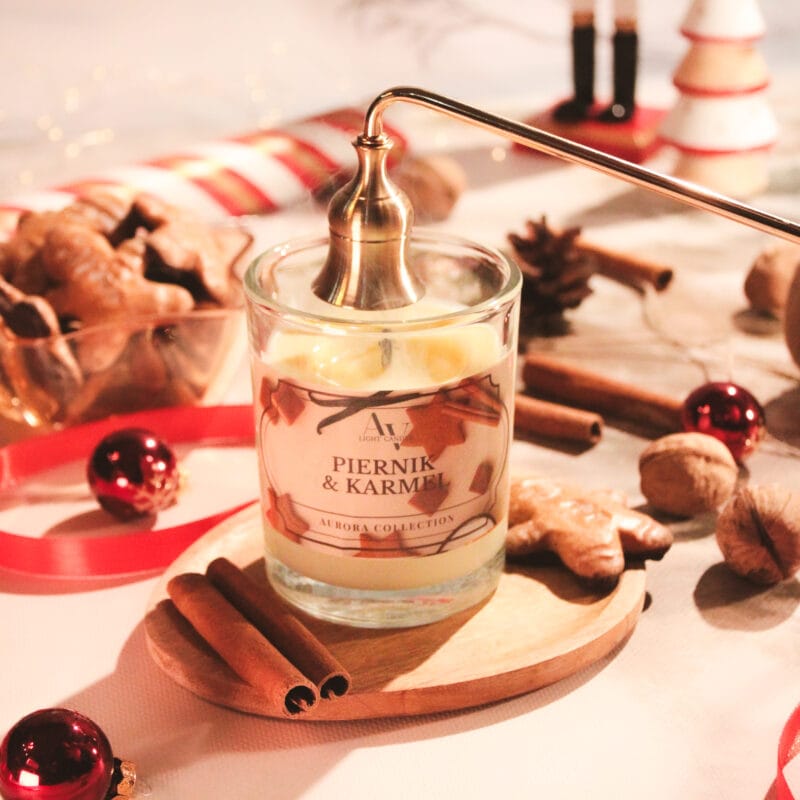Zbliżenie na świecę Piernik i Karmel 200 ml z kolekcji Aurora z dekoracjami zimowymi i pierniczkiem