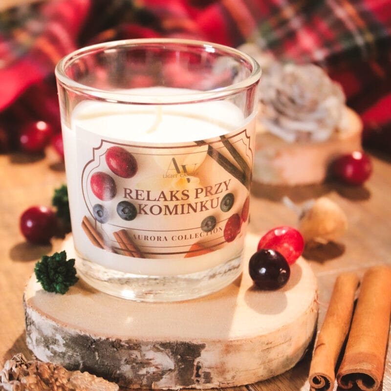 Zbliżenie na świecę Relaks przy Kominku – etykieta z cynamonem i owocami leśnymi, słoik na drewnianej podstawce