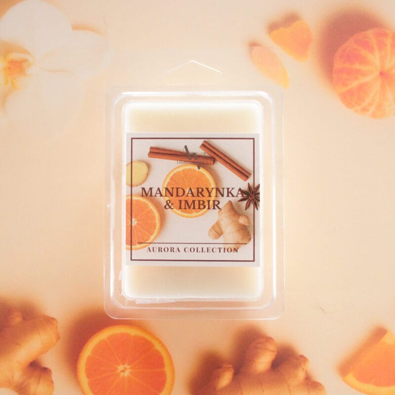 Wosk zapachowy Mandarynka i Imbir AV Light Candle na tle plasterków mandarynki, imbiru i cynamonu.