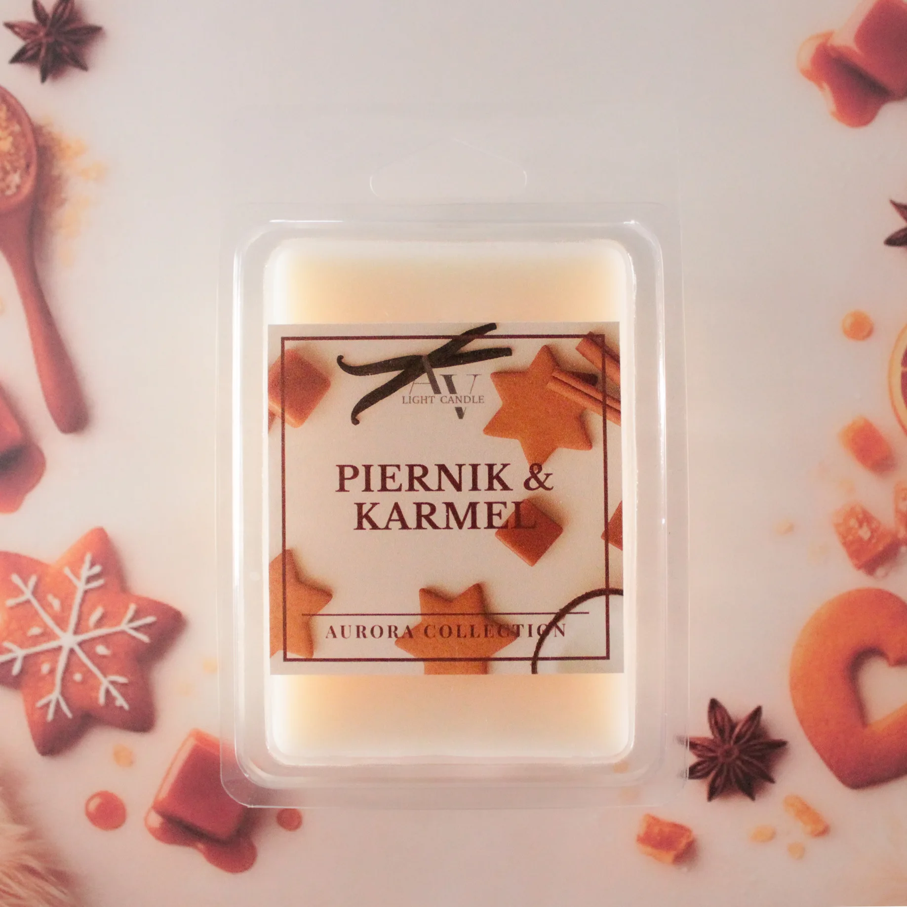 Wosk zapachowy Piernik i Karmel AV Light Candle na tle pierników, karmelu i przypraw korzennych.