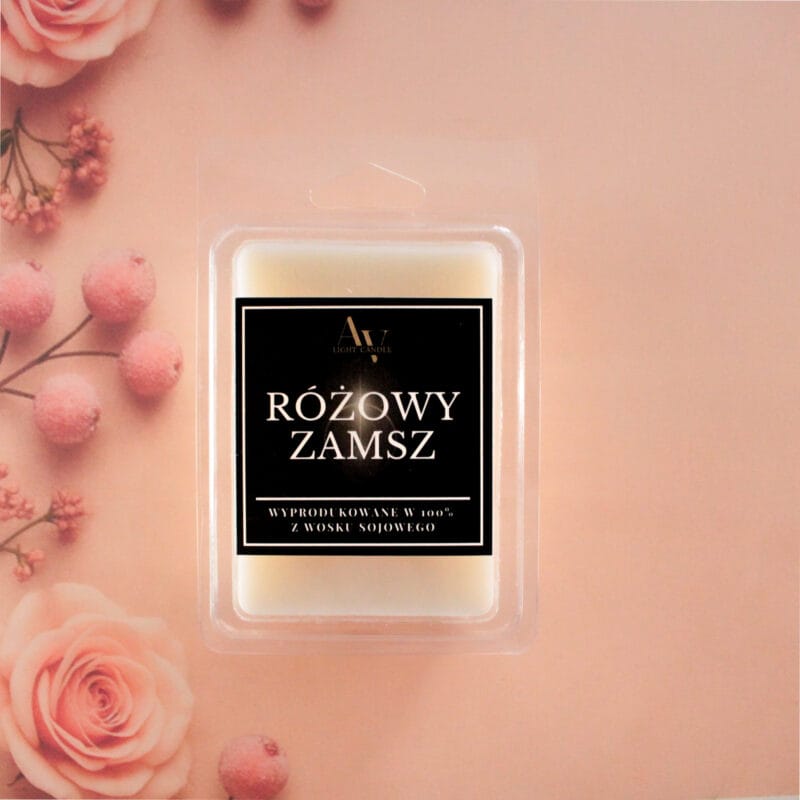 Wosk zapachowy Różowy Zamsz AV Light Candle na tle róż i pudrowych dekoracji.