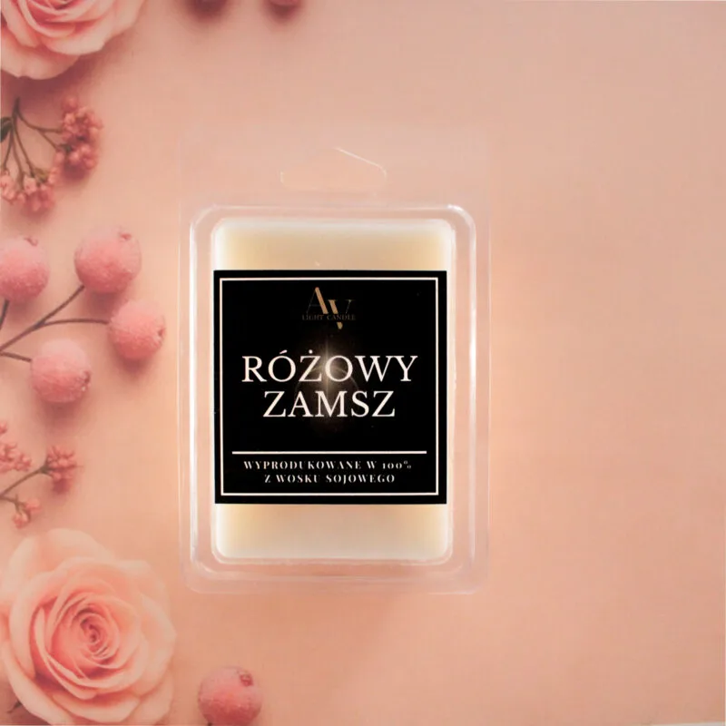 Wosk zapachowy Różowy Zamsz AV Light Candle na tle róż i pudrowych dekoracji.