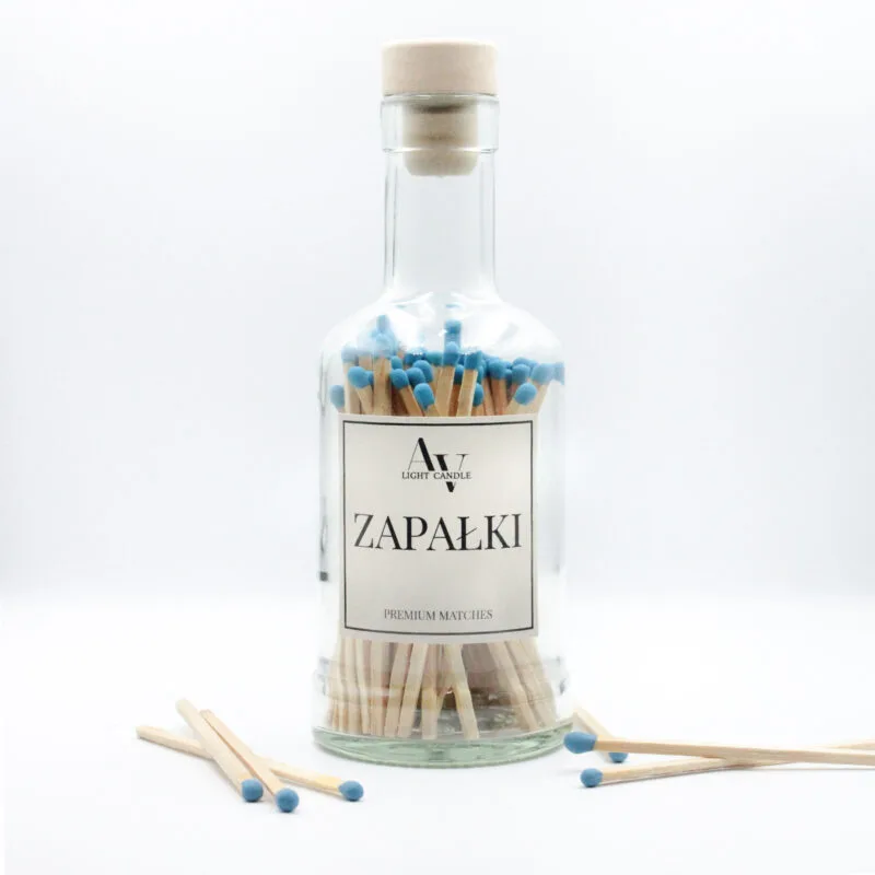 Szklana butelka z długimi zapałkami AV Light Candle z niebieskimi główkami, minimalistyczna etykieta i korek drewniany na białym tle.