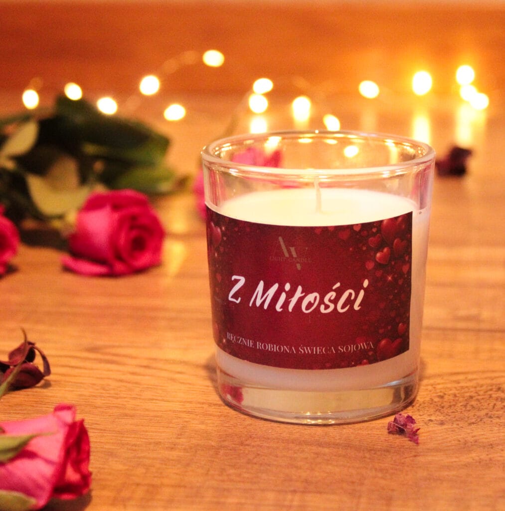 Świeca sojowa Z Miłości AV Light Candle na drewnianym blacie, walentynkowa etykieta i czerwone róże w tle